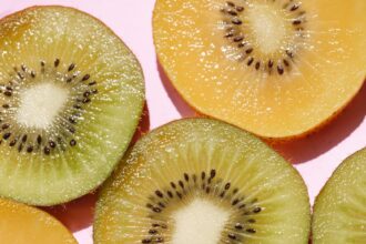 sliced juicy kiwi on pink background